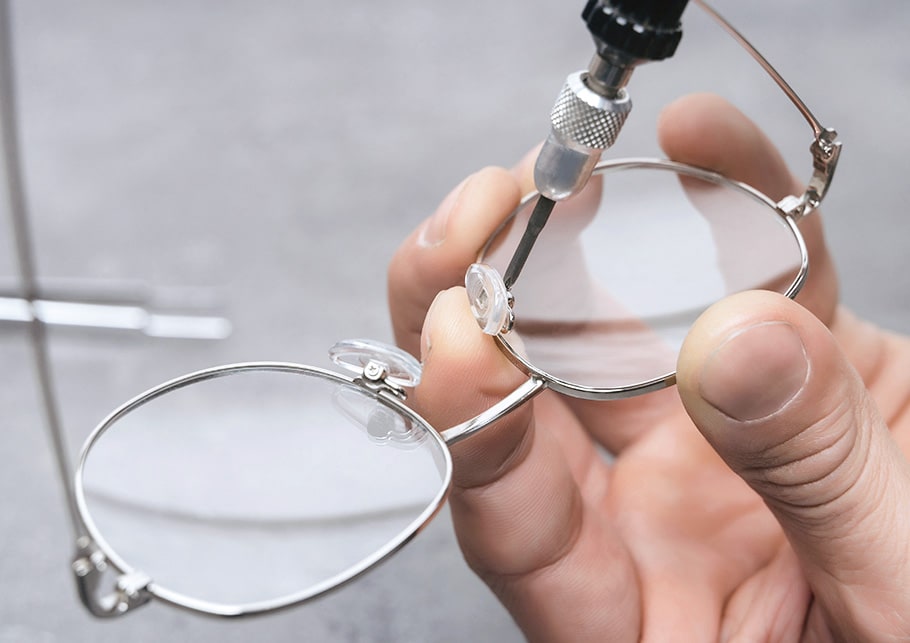 An optician repairing a pair of glasses frames for a patient