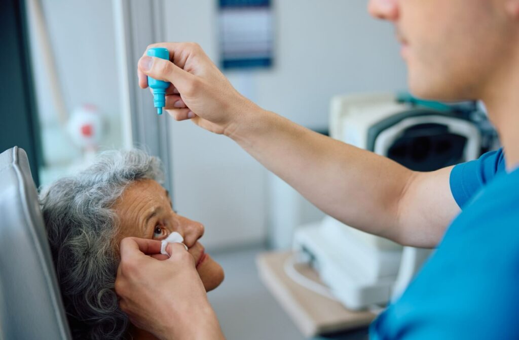 An optometrist administers dilating eye drops to a patient during their exam.